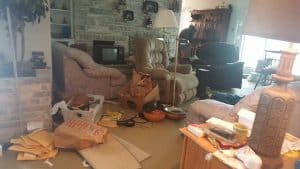 A close-up shot of a messy living room in Long Island, NY, shows a variety of items strewn about.