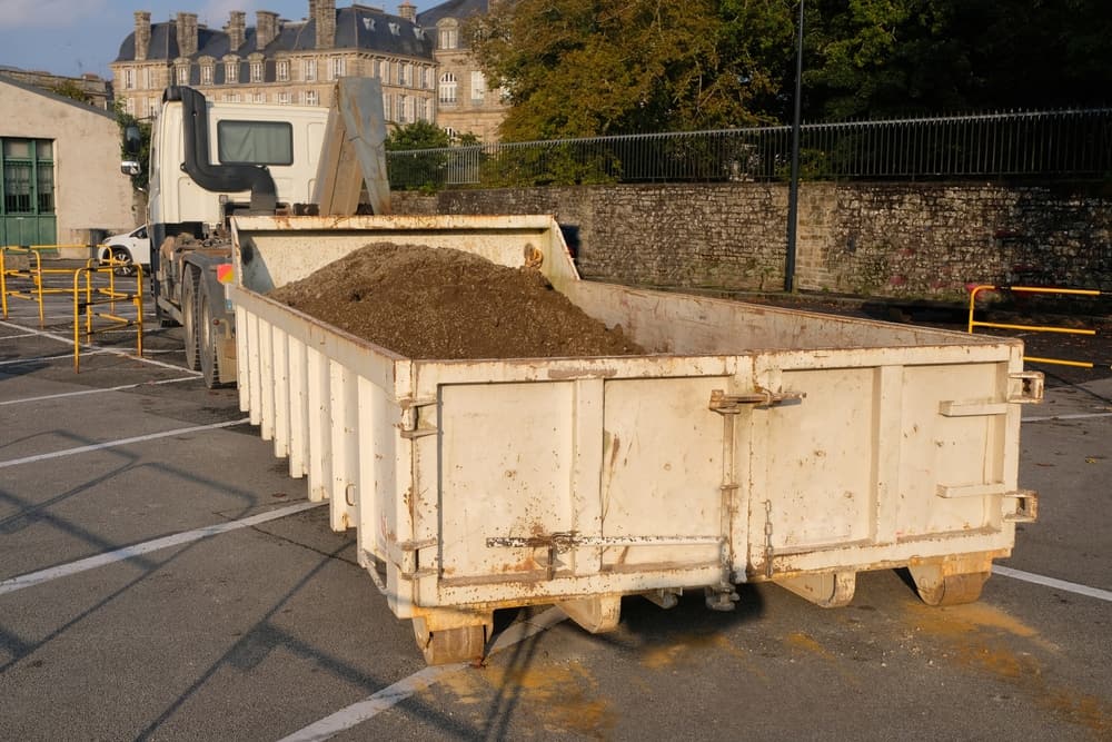 Truck with removable dumpster filled with soil